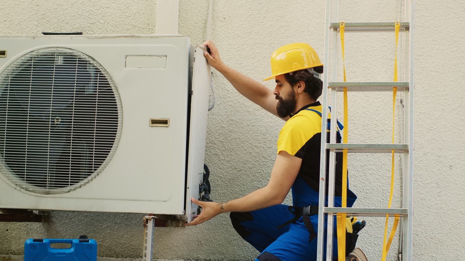 Technician disassembling a split air conditioner during installation work